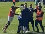 Shocking moment York player PUNCHES a Rochdale fan amid chaotic mid-match pitch invasion which saw them swipe promotion deep into injury time