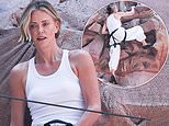 Charlize Theron overcomes her fear of heights as she scales climbing wall set into a giant billboard in Times Square to promote new film
