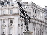 Banksy confirms London’s newest statue is his work after suited figure with a flag covering his face popped up on Pall Mall