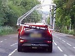 Own goal! Driver is pulled over by police for balancing football goalpost on car roof