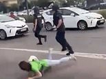 Moment riot police officer shoves protester to the ground from behind as she walks along street