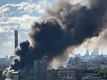 Around 100 firefighters battle huge blaze at recycling centre as thick plumes of smoke billow across London skyline