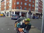 Moment woman cyclist with THREE children riding on back pedals through a red light and holds up her hand to try and stop cars as she dodges traffic