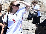 Adele shows her support for footballer John Stones by wearing a number five England shirt while in Sardinia with fashion designer Tom Ford